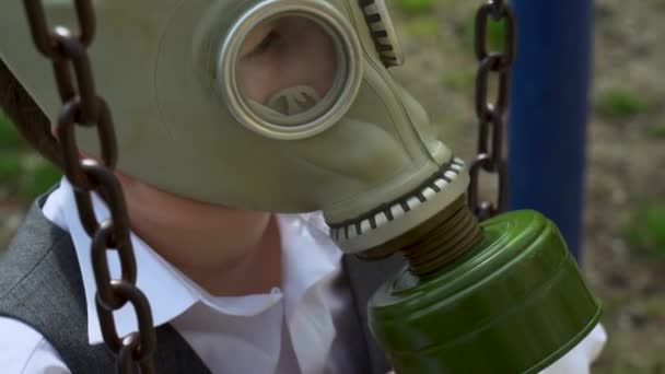 学校のスーツ姿の生徒の肖像画 子供はゆっくりと空中や放射性物質中の細菌剤から軍事保護ガスマスクのスイングに乗る 隔離中は健康に気をつけて — ストック動画
