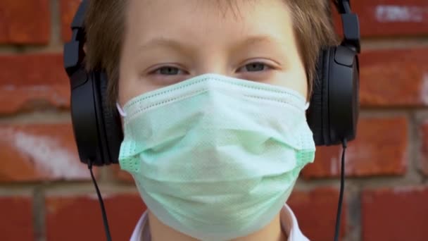 Kulaklıklı Koruyucu Tıbbi Maske Takan Beyaz Yakışıklı Çocuk Dışarıda Kırmızı — Stok video