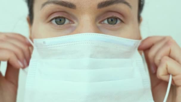 漂亮的绿眼睛女护士 戴着蓝色防护医疗面罩 近身白色背景 流行情况下医生的画像 Covid 19或Corona病毒大流行病年 — 图库视频影像