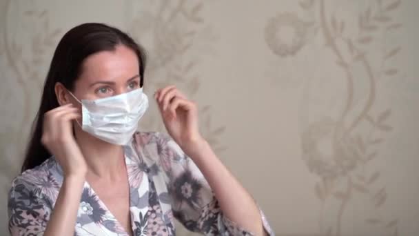 Prachtig Blank Brunette Meisje Bloemengewaad Zet Een Beschermend Medisch Gezichtsmasker — Stockvideo