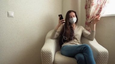 Yalnız, beyaz tenli, bej bluzlu, koruyucu bir yüz maskesi takan, kulakları kulaklarında kulaklıkla koltukta oturan, sabahları müzik eşliğinde dans eden esmer bir kadın. Evde yalnızlık.