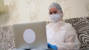 Hasta ve enfekte olmuş genç bir kız toplumdan izole edilmiş. Beyaz koruyucu elbiseli, maskeli, mavi eldivenli dizüstü bilgisayar kullanan, yazı yazan, sörf yapan yalnız bir kadın. Karantina karantinasında uzaktan çalışma.