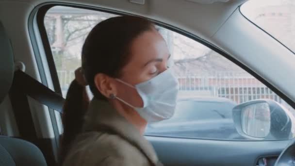 快乐而漂亮的小女孩 穿着冬季夹克 留着深褐色的马尾辫 戴着一副有保护作用的医疗面罩 司机在车里跳舞 靠得很近 Covid 19病毒威胁的保护概念 — 图库视频影像