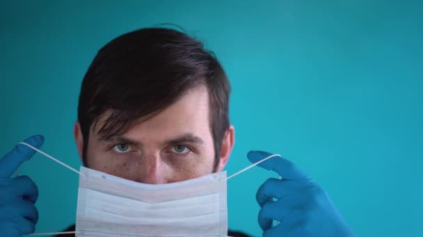 Tıbbi Eldivenli Yakışıklı Genç Adam Beyaz Koruyucu Yüz Maskesi Takıyor — Stok video