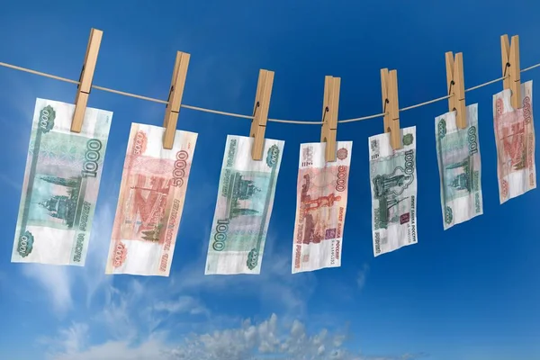 Banconota accartocciata di rubli da asciugare sui perni di corda attaccati Immagine Stock