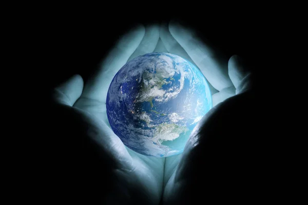 男人的手捧着行星地球在黑色的背景下以蓝色的光芒旋转着北美洲和南美的大陆 — 图库照片