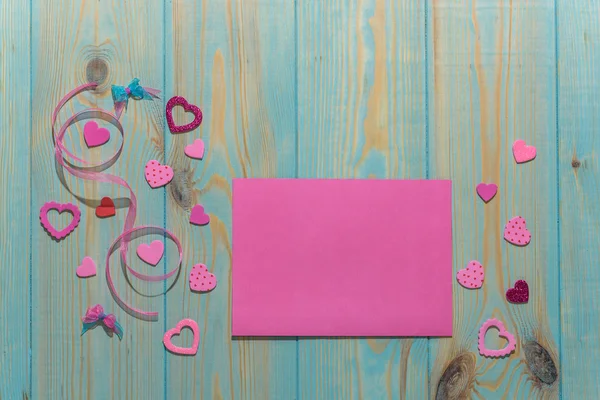 Valentines day toy heart and notepad paper page for your text. Top view on blue wooden table. — Stock Photo, Image