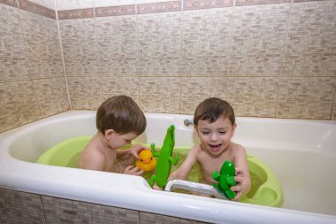 İki küçük ikiz çocuklar tarafından banyo su ile birlikte oyun