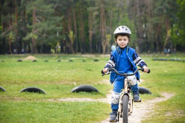 Eğleniyor ilk bisikletini güneşli yaz gününde mutlu sevimli sarışın çocuk çocuk