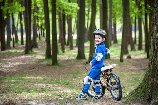 Szczęśliwy chłopiec 4 lat zabawy w lesie jesienią lub latem z rowerem — Zdjęcie stockowe