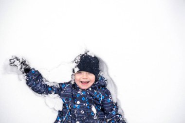 Çocuk Kuzey Kutbu kar üzerinde yatıyor. kis mutlu ve gülümseyerek.