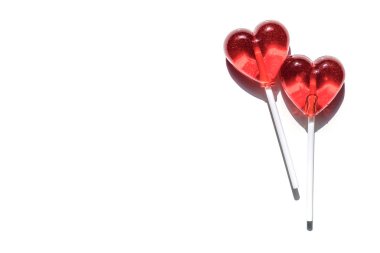 İki lolipop. Kırmızı kalpler. Şeker. Aşk kavramı. Sevgililer günü