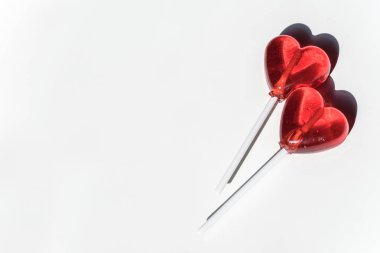 İki lolipop. Kırmızı kalpler. Şeker. Aşk kavramı. Sevgililer günü