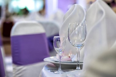 Gözlük, çatal, bıçak, peçete ve dekoratif çiçek bir masada akşam yemeği için rahat restoranda servis.