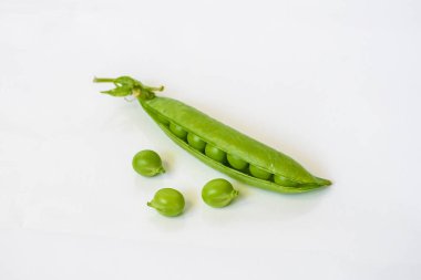 Beyaz arkaplanda taze bezelyeler izole edildi