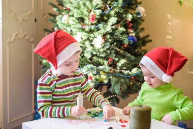Eller tarafından x-mas süslemeleri yapmak çocuklar kardeşler çocuk çocuklar