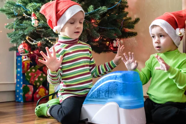 Två söta pojkar spelar med fungerande luftfuktare, väntar x-mas — Stockfoto