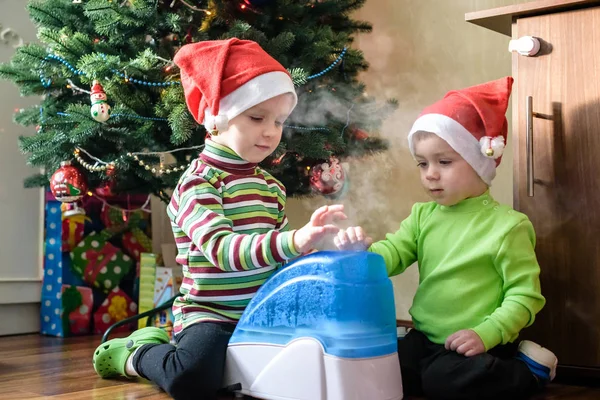 Two adorable boys playing with working humidifier, waiting for x-mas — Stock Photo, Image