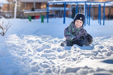 Karda atlama çocuk. Mutlu bir çocukluk açık havada kış şehirde yürüyüş. Çocuk gülen ve having fun.