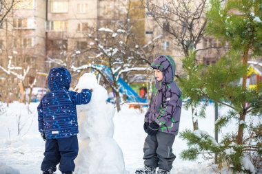 İki küçük kardeşi bir kardan adam yapma, oyun ve kar, açık havada soğuk gününde eğleniyor çocuklar çocuklar. Kış çocuklarda etkin boş.