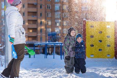 Anne ve iki oğlu güzel kış günü açık havada zevk
