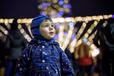 Aile, çocukluk, sezon ve insanlar kavramı - kış giysileri karlı şehir arka plan üzerinde mutlu