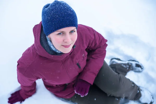 Piękna kobieta dmuchanie na śniegu, w lesie sosnowym — Zdjęcie stockowe