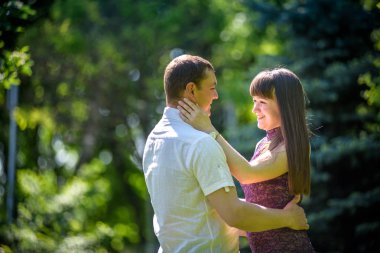 Sevgi dolu genç çift yaz parkta yürümek.