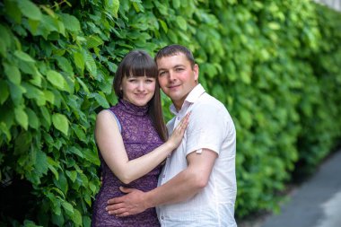 Sevgi dolu genç çift yaz parkta yürümek.