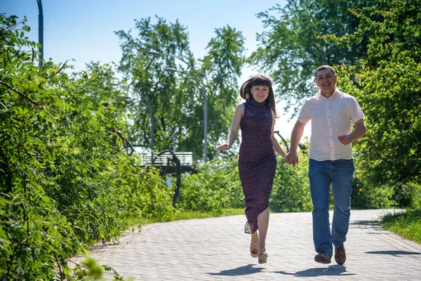 Sevgi dolu genç çift yaz parkta yürümek.