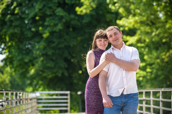 Sevgi dolu genç çift yaz parkta yürümek.