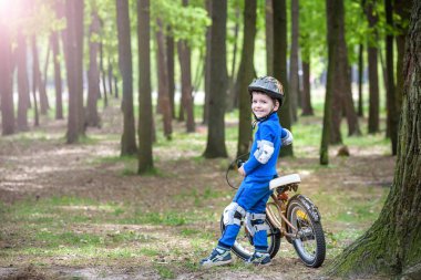 Sevimli sarışın çocuk mutlu çocuk eğleniyor ilk bisikletini güneşli yaz günü, açık havada. Spor yapma çocuk. Çocuklar için etkin boş. kask giymek. gülümseyen ve cicling.