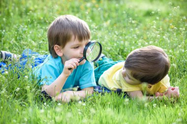 İki erkek kardeş ile Büyüteç camı açık havada.