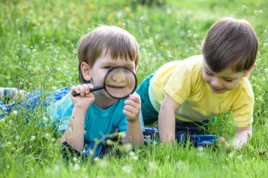 İki erkek kardeş ile Büyüteç camı açık havada.