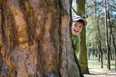 Saklambaç oynayan sevimli küçük çocuk