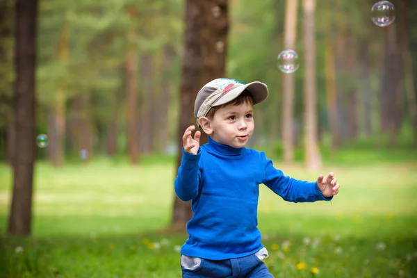 Little boy with soap bubbles in summer park. — Stock Photo, Image