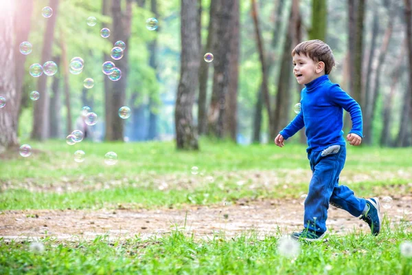 Niño con burbujas de jabón en el parque de verano . — Foto de Stock