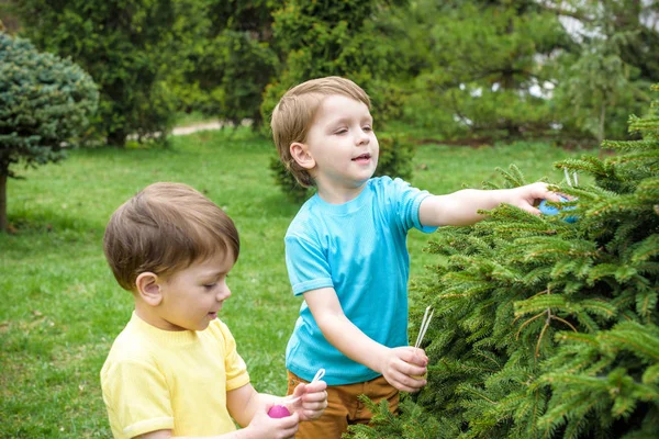 Enfants sur la chasse aux œufs de Pâques dans le jardin de printemps en fleurs. Les enfants saisissent — Photo