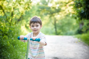çocuk onun scooter yerel parkta oynarken