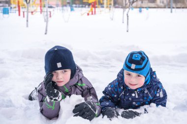Karda oturan iki Çocuk Bahçesi peyzaj kaplı. Kış ağaçlarıyla ve buz, dağ görünümünde arka plan.