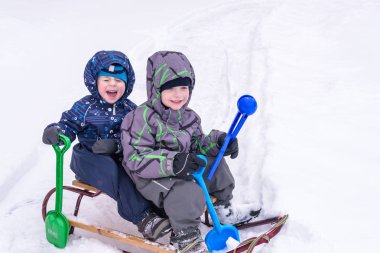 Kış tatil eğlenceli. İki erkek birlikte bir pleasan üzerinde kayma var