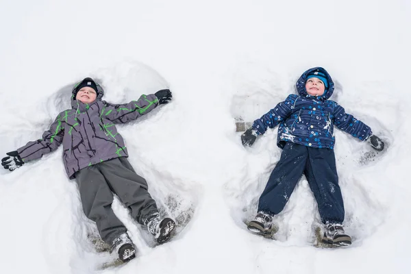 Due fratellini bambini ragazzi in vestiti invernali colorati che fanno s — Foto Stock