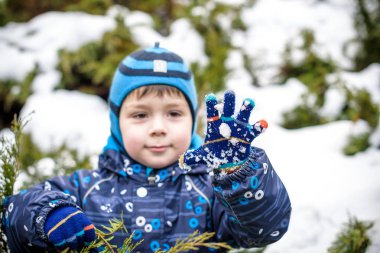 Çocuk çocuk açık havada kar yağışı sırasında renkli giysiler içinde kış portresi. Kış soğuk karlı günlerde çocukları ile etkin outoors eğlence. Ormanda kar ile eğleniyor mutlu yürümeye başlayan çocuk