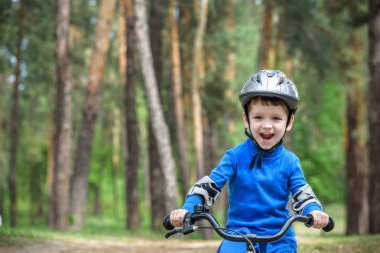 3 yıl ve babasının bir bisiklet ile sonbahar ormandaki küçük çocuk çocuk. Baba öğretim evlat. Adam başarı hakkında mutlu. Çocuk kask. Güvenlik, spor, boş zaman çocuklar kavramı