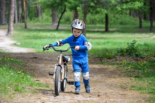 Велосипедная авария. Концепция безопасности детей. Мальчик перевозит свой велосипед на место ремонта . — стоковое фото