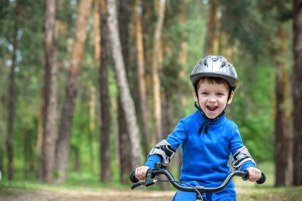 Маленький 3-летний мальчик и его отец в осеннем лесу на велосипеде. Отец учит сына. Человек рад успеху. Детский шлем. Безопасность, спорт, досуг детей — стоковое фото