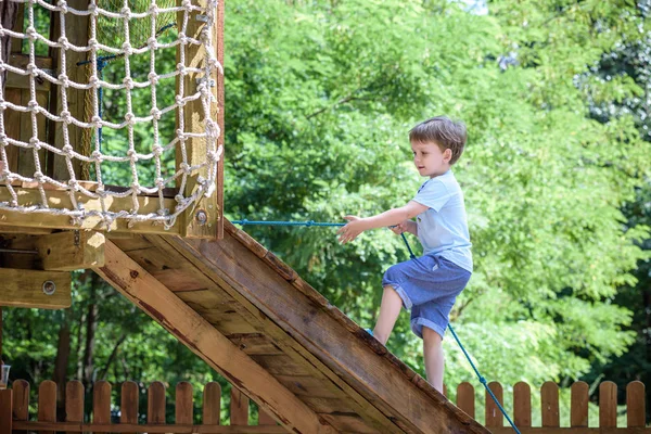 Little toddler boy kid having fun at a wooden playground outdoor — Stock Photo, Image