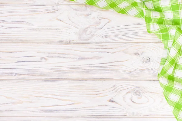 Green towel over wooden kitchen table. View from above with copy space — Stock Photo, Image