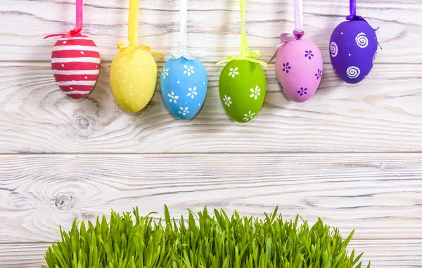 Colorate uova di Pasqua appese su uno sfondo di legno rustico con spazio. sfondo uova di Pasqua — Foto Stock
