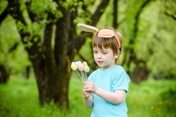 Kleine jongen op paaseieren jagen in de lentetuin op de dag. Schattig — Stockfoto